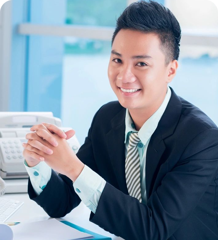 A man in suit and tie sitting at desk.